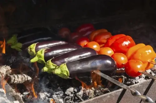 Legumes sendo preparados na churrasqueira.